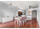 Open-concept dining area with modern light fixture, a view to the kitchen, and hardwood flooring at 9563 Myrtle Creek Ln, Orlando, FL 32832