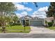 Charming single-story home featuring a well-manicured lawn, mature landscaping, and an attached two-car garage at 9563 Myrtle Creek Ln, Orlando, FL 32832