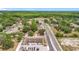 An aerial view showcasing the property with lush green trees and nearby parking area, and road at 1000 E Dixie Ave, Leesburg, FL 34748