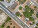 An aerial view of the area, showcasing the property, road, parking, and surrounding houses and trees at 1000 E Dixie Ave, Leesburg, FL 34748