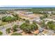 Aerial view with lush trees, lake in distance, road, and new construction buildings at 1000 E Dixie Ave, Leesburg, FL 34748