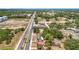Wide aerial view of the area, with views of the city, road, property, parking, and lush trees at 1000 E Dixie Ave, Leesburg, FL 34748