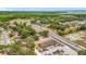 Aerial view displaying the property, road, a lake in the distance, and lush surrounding trees at 1000 E Dixie Ave, Leesburg, FL 34748