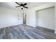 Bright bedroom featuring hardwood floors, ceiling fan, and closet space at 1000 E Dixie Ave, Leesburg, FL 34748
