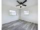 Bright bedroom with gray wood-look flooring has a ceiling fan and a sunny window view at 1000 E Dixie Ave, Leesburg, FL 34748