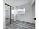Bright bedroom features modern gray wood-look flooring and a mirrored closet with a sunlit window view at 1000 E Dixie Ave, Leesburg, FL 34748
