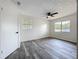 Bedroom featuring wood-look vinyl flooring, two windows and a ceiling fan at 1000 E Dixie Ave, Leesburg, FL 34748