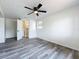 Bedroom featuring wood-look vinyl flooring, white walls, ceiling fan and bathroom access at 1000 E Dixie Ave, Leesburg, FL 34748