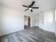 Bedroom featuring wood-look vinyl flooring, white walls and access to other rooms at 1000 E Dixie Ave, Leesburg, FL 34748