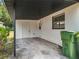 Attached carport with storage and two trash cans at 1000 E Dixie Ave, Leesburg, FL 34748