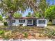 Charming single-story home featuring a freshly painted exterior, complemented by a mature tree with Spanish moss at 1000 E Dixie Ave, Leesburg, FL 34748
