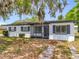 Inviting single-Gathering home with a classic exterior, featuring dark shutters and a cozy, screened front porch at 1000 E Dixie Ave, Leesburg, FL 34748