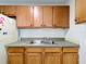 Kitchen sink and cabinets featuring a stainless steel sink and wood cabinets at 1000 E Dixie Ave, Leesburg, FL 34748