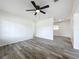 Bright living room featuring fresh paint, ceiling fan, and new gray toned laminate flooring at 1000 E Dixie Ave, Leesburg, FL 34748