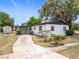 View of the home's exterior with a covered carport and additional storage shed, set against a clear blue sky at 1000 E Dixie Ave, Leesburg, FL 34748