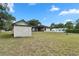Expansive grassy backyard with shed, screened-in porch and mature trees at 10059 Sali Dr, Orlando, FL 32817
