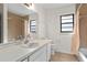 Bright bathroom with a large mirror, a single sink vanity, a window, and a shower/tub combination with tile surround at 10059 Sali Dr, Orlando, FL 32817