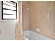 Shower/tub combination with tile surround and a window provides natural light at 10059 Sali Dr, Orlando, FL 32817