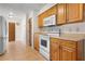 Well-lit kitchen featuring wood cabinetry, white appliances, and tile floors at 10059 Sali Dr, Orlando, FL 32817