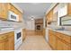 Spacious kitchen showcasing white appliances and access to the living room fireplace at 10059 Sali Dr, Orlando, FL 32817