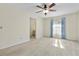 Bright living room with neutral carpet, ceiling fan, and large window at 10059 Sali Dr, Orlando, FL 32817