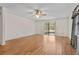 Bright living room with light hardwood floors, ceiling fan, and sliding glass door at 10059 Sali Dr, Orlando, FL 32817