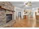 Open living space featuring hardwood flooring, brick fireplace, and kitchen access at 10059 Sali Dr, Orlando, FL 32817