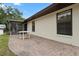 Back patio with brick pavers, table and screened in porch on a sunny day at 10059 Sali Dr, Orlando, FL 32817
