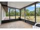 Relaxing screened-in patio with tiled floors offering serene views of the expansive backyard at 10059 Sali Dr, Orlando, FL 32817