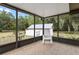 Relaxing screened porch with tile floor and view of the backyard shed at 10059 Sali Dr, Orlando, FL 32817