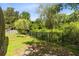 Landscaped backyard with an iron fence, lush greenery, and shade at 1014 Seminole Creek Dr, Oviedo, FL 32765