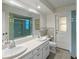 Well-lit bathroom featuring double sinks and a tile backsplash at 102 Old Hickory, Longwood, FL 32750