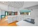 Bright kitchen featuring white cabinetry and tile countertops, open to a large living area at 102 Old Hickory, Longwood, FL 32750