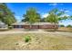 Charming brick home with an expansive front yard and mature trees under a sunny blue sky at 106 8Th St, Lake Hamilton, FL 33851
