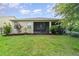 Green lawn with a covered patio and well-kept garden create a relaxing outdoor living space at 1089 Seburn Rd, Apopka, FL 32703