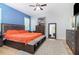 Bright bedroom features an orange blanket, accent wall, ceiling fan, and decorative rug at 1089 Seburn Rd, Apopka, FL 32703
