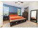 Bright bedroom features an orange blanket, accent wall, ceiling fan, and decorative rug at 1089 Seburn Rd, Apopka, FL 32703