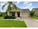 Charming single-Gathering home featuring a well-manicured lawn, two-car garage, and tropical landscaping at 1089 Seburn Rd, Apopka, FL 32703