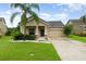 Charming single-Gathering home featuring a well-manicured lawn, two-car garage, and tropical landscaping at 1089 Seburn Rd, Apopka, FL 32703