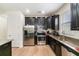 Modern kitchen features stainless appliances, stone countertops, dark cabinets, and hardwood floors at 1089 Seburn Rd, Apopka, FL 32703