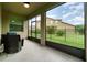 Screened lanai with wicker seating area and view of the fenced backyard at 1089 Seburn Rd, Apopka, FL 32703