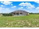Backyard view of the screen enclosed pool and green lawn, providing a private and spacious outdoor space at 11115 Romance Ct, Winter Garden, FL 34787
