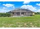 Expansive backyard featuring a screen-enclosed pool, lush greenery, and ample space for outdoor activities at 11115 Romance Ct, Winter Garden, FL 34787