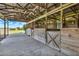 Barn with concrete floor and wooden horse stalls featuring X-shaped doors at 11115 Romance Ct, Winter Garden, FL 34787
