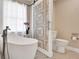 A modern bathroom with a freestanding tub, ornate shower door, and neutral color scheme at 11115 Romance Ct, Winter Garden, FL 34787