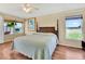 A cozy bedroom with a four-poster bed, ceiling fan and scenic outdoor views at 11115 Romance Ct, Winter Garden, FL 34787