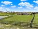 Spacious ranch-style home features lush green surroundings with an expansive fenced yard and distant horse barn at 11115 Romance Ct, Winter Garden, FL 34787