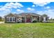 Charming single-story home featuring a red door, well-manicured lawn, and beautiful landscaping at 11115 Romance Ct, Winter Garden, FL 34787