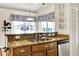 Kitchen with granite countertops, wood cabinets, stainless steel dishwasher and large windows at 11115 Romance Ct, Winter Garden, FL 34787