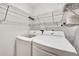 A laundry room featuring a washing machine and dryer with metal racks to maximize storage at 11115 Romance Ct, Winter Garden, FL 34787